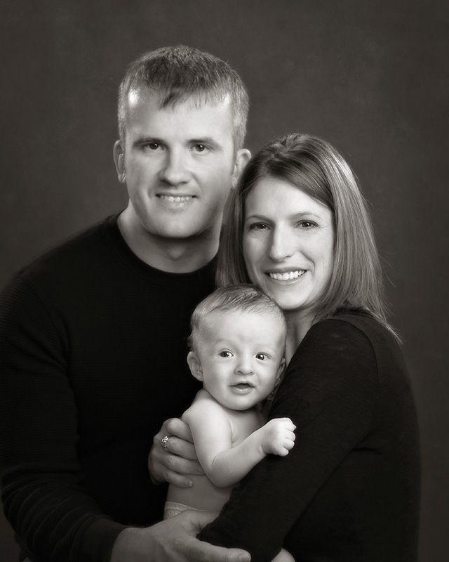 black and white portrait of young family hold their three month baby by Dan Cleary of Cleary Creative Photography in Dayton Ohio