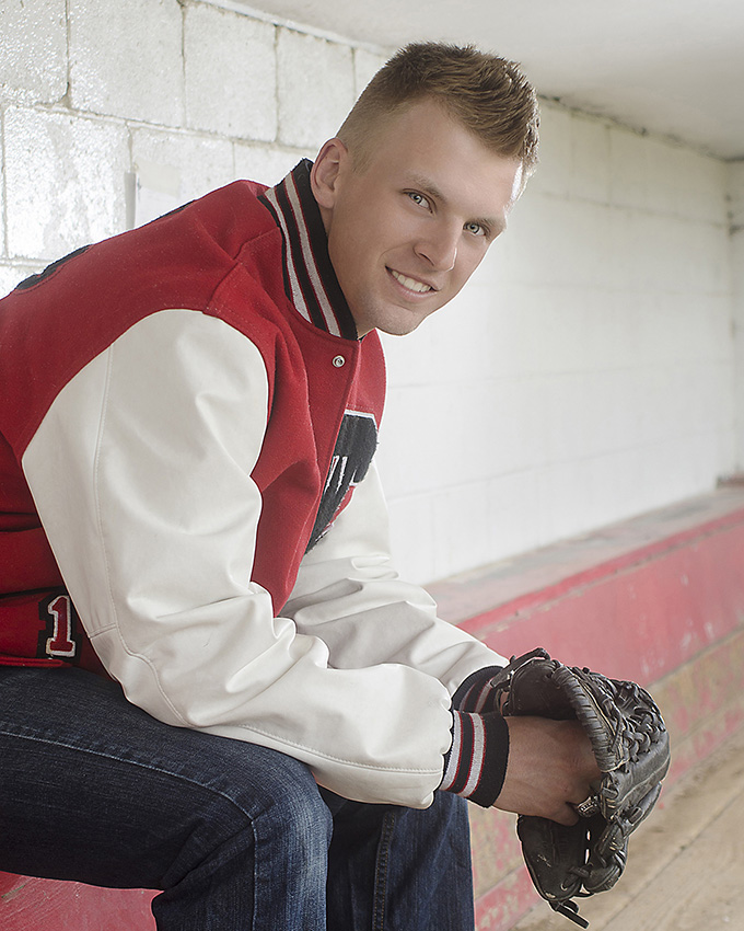 high school senior portrait of boy with baseball glove in dugout Dan Cleary of Cleary Creative Photography in Dayton Ohio