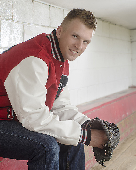 portrait of High School senior boy in dugout with baseball glove by Dan Cleary of Cleary Creative Photography in Dayton Ohio 