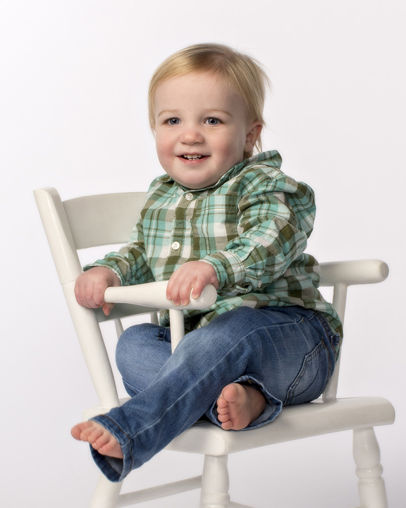 portrait of 1 year old baby boy laughing sitting in a chair by Dan Cleary of Cleary Creative Photography in Dayton Ohio