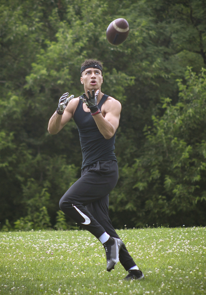 high school senior football player catching a football by Dan Cleary of Cleary Creative Photography